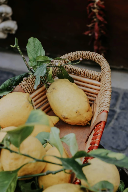 a wicker basket filled with lemons and a few leaves