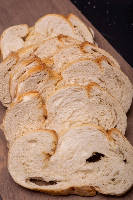 an assortment of slices of white bread sitting on top of wooden boards