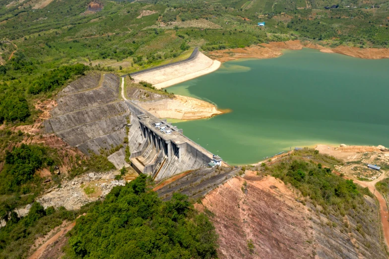 a very high dam near the mountains is made of concrete