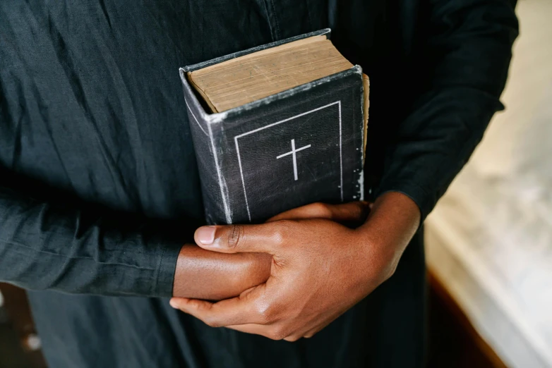 a man is holding an empty bible, and a book has been written on it