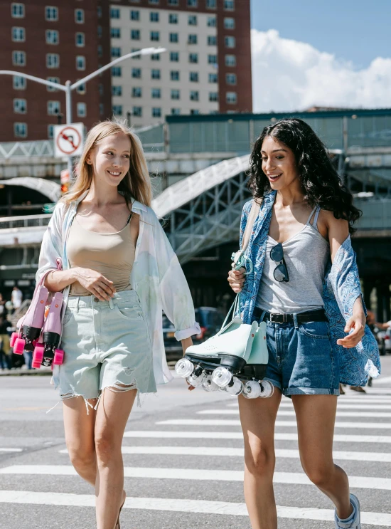 two girls wearing short shorts crossing the street