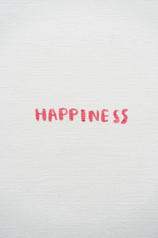 a word in red ink that says happiness on a white surface