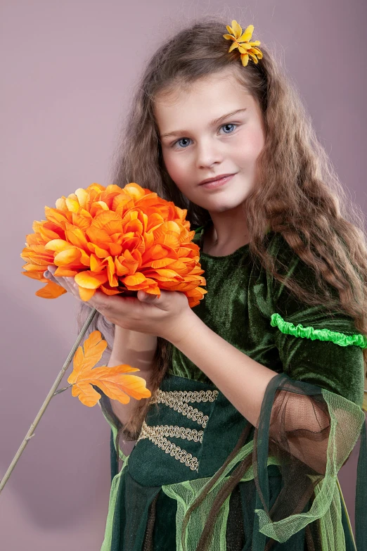 a pretty little girl in a princess costume holding a bunch of flowers