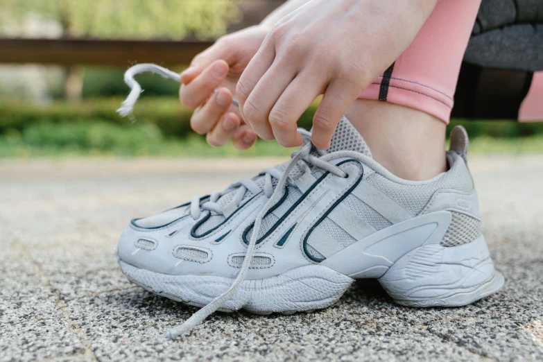 the person is tying up on one shoe