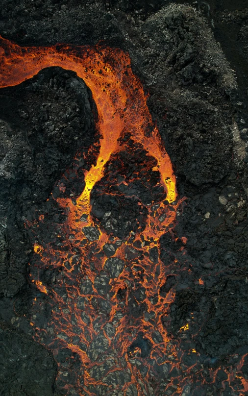 a lava fire in a rocky ground next to a small patch of grass