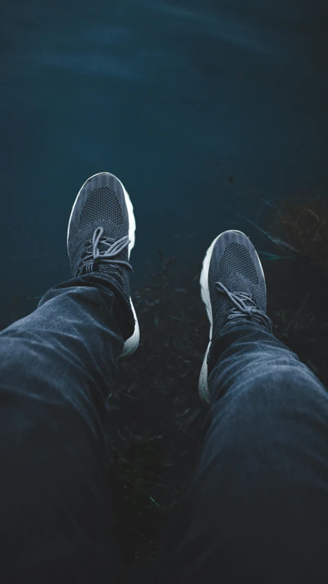 a person's feet in front of the camera with a black and blue background