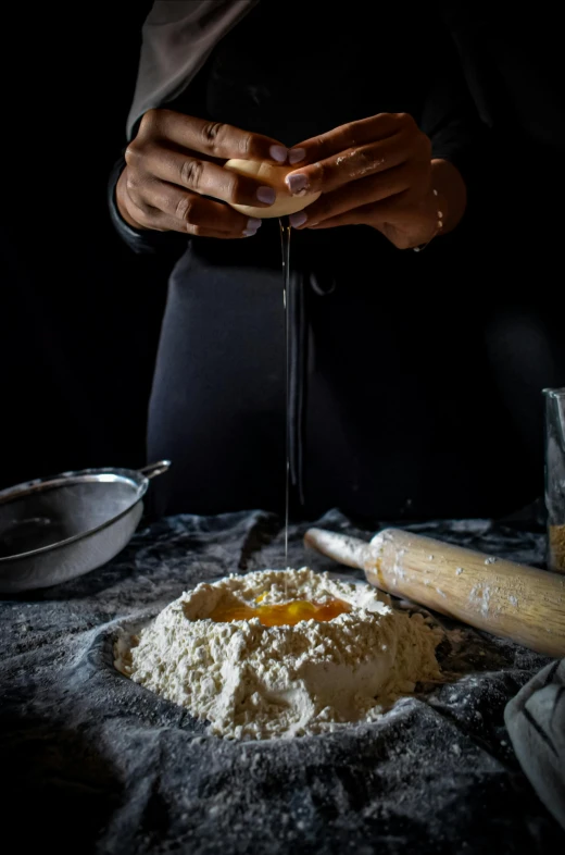 woman pouring powdered sugar over bread dough