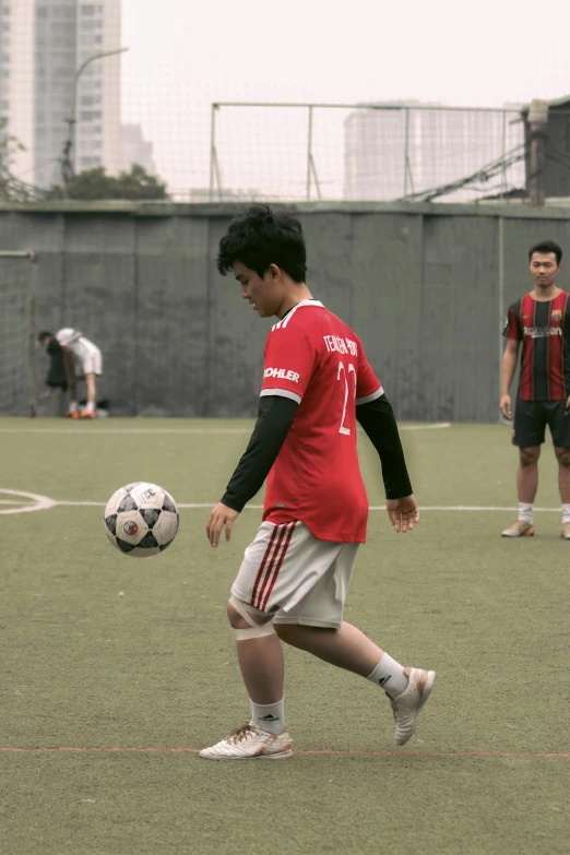 three young men playing soccer on a field