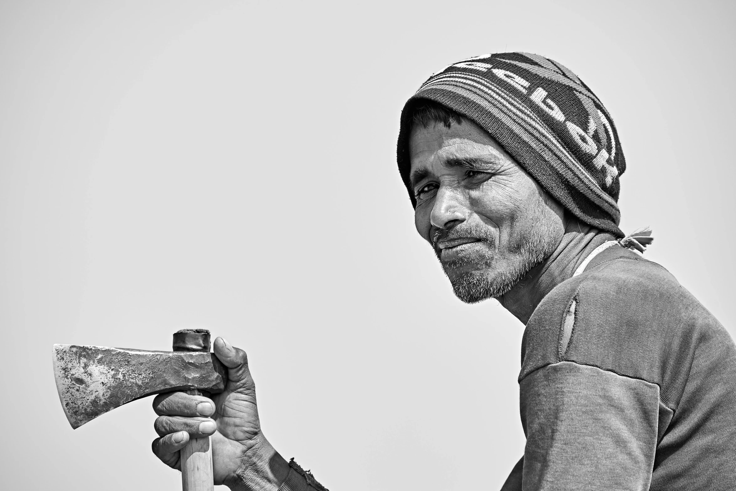 a man with a beard and a hat holding a hammer