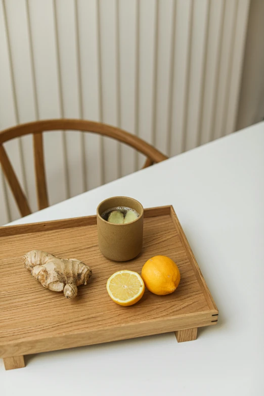 the tray has a cup and oranges on it