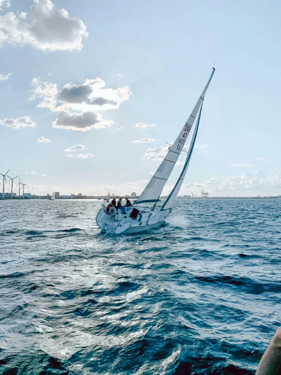 a sailboat sailing in the water with people sitting on it