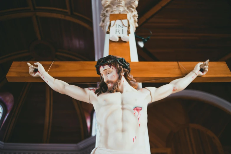 a fake jesus statue holding a wooden cross