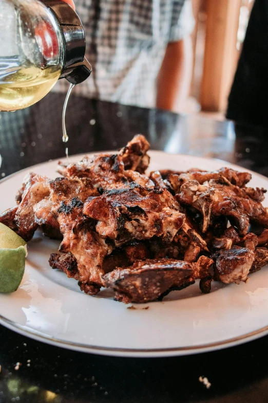 a plate filled with pieces of meat being poured