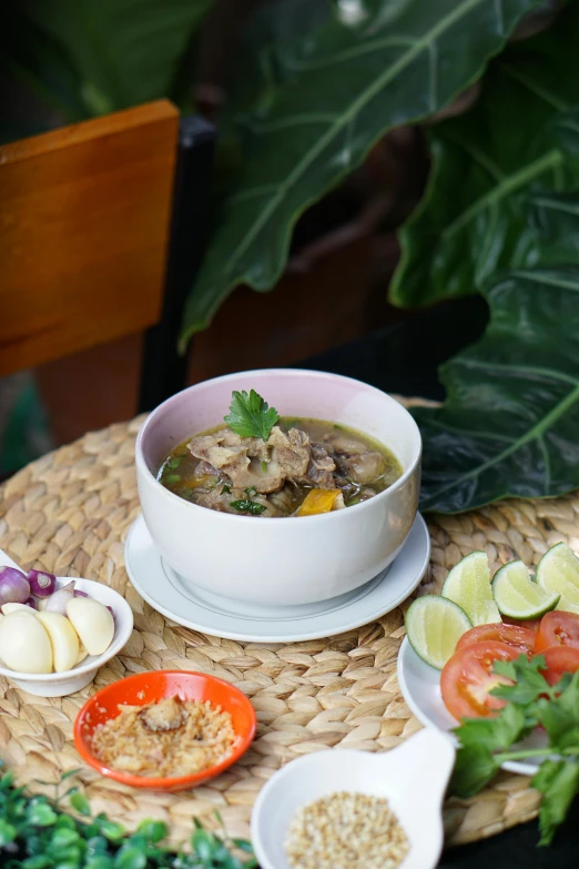 some bowls of soup and vegetables sitting on a table