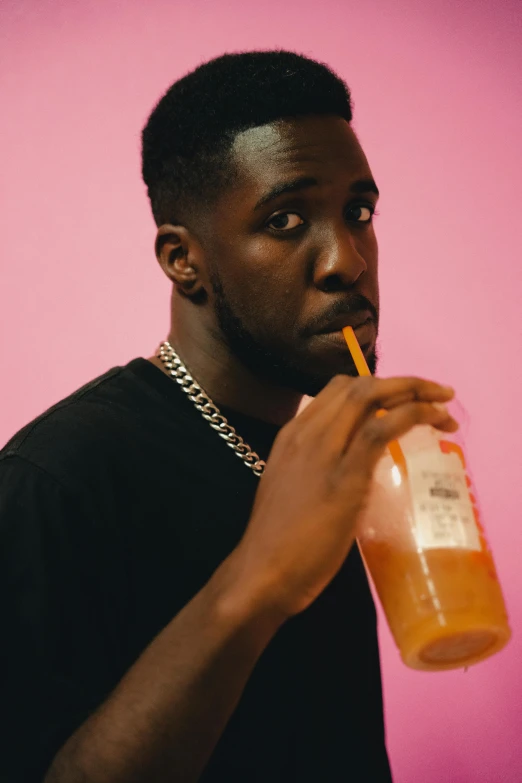 man drinking an orange juice from a glass