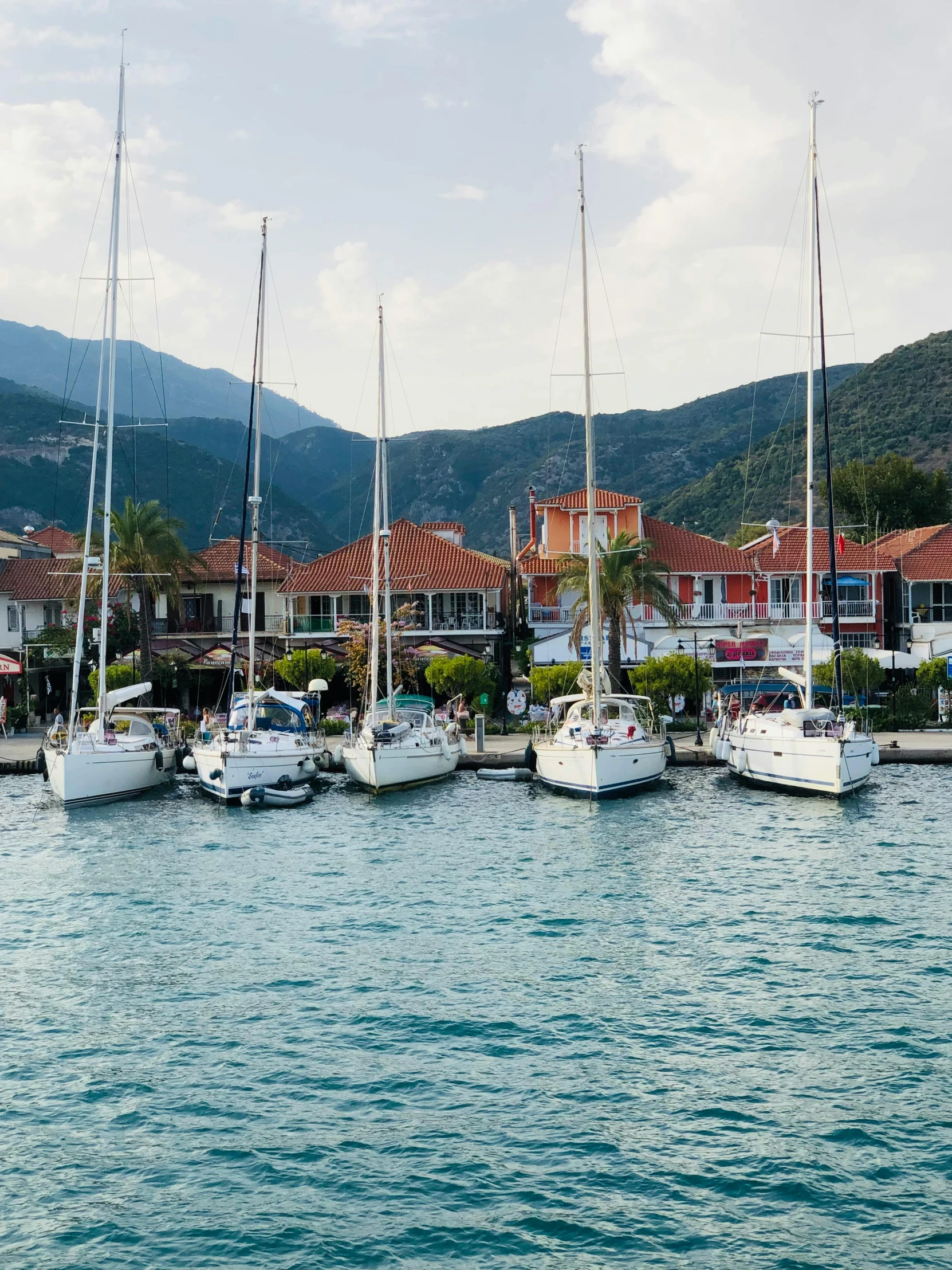 a group of sail boats are moored in a bay