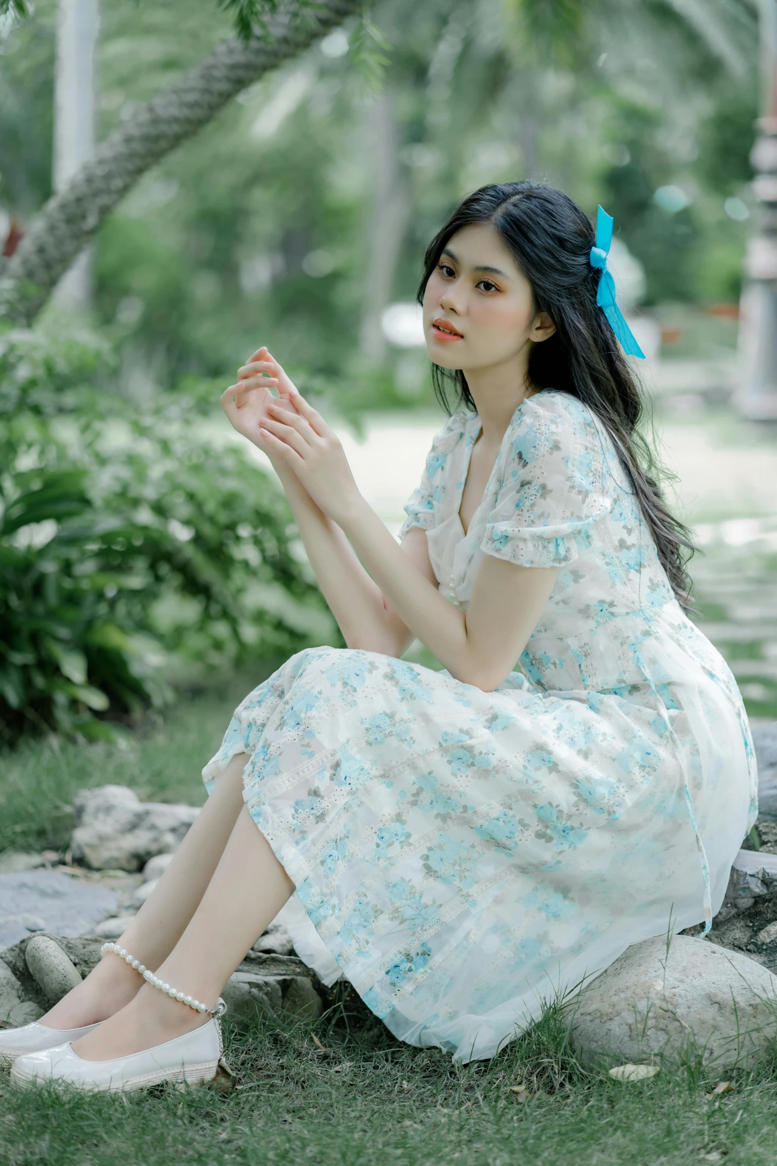 a woman sitting on the ground in a dress