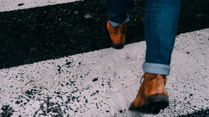 the person has brown shoes on, and are walking down a street