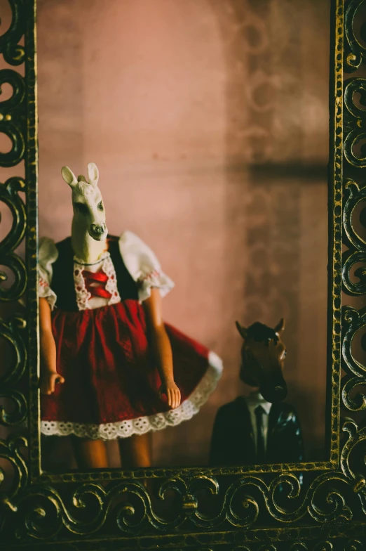 a doll sitting in front of a mirror with a kangaroo on top