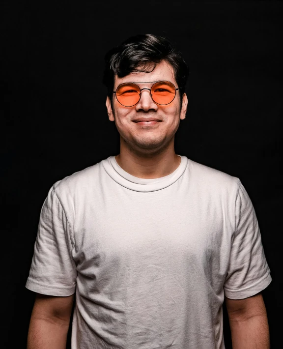 a man wearing sunglasses smiles at the camera