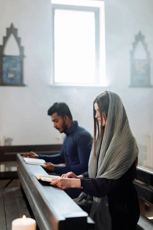 two people sit in a pew at a pew circle