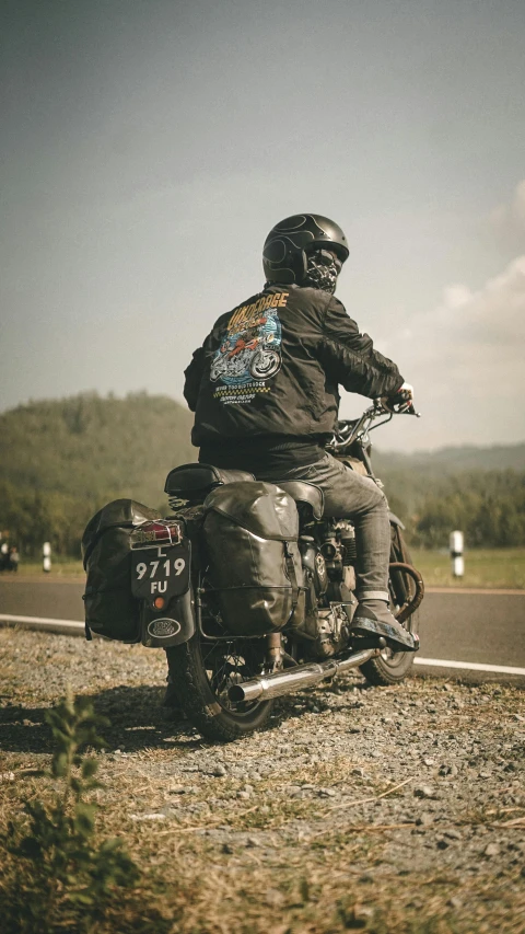 a person riding on the back of a motorcycle on the road