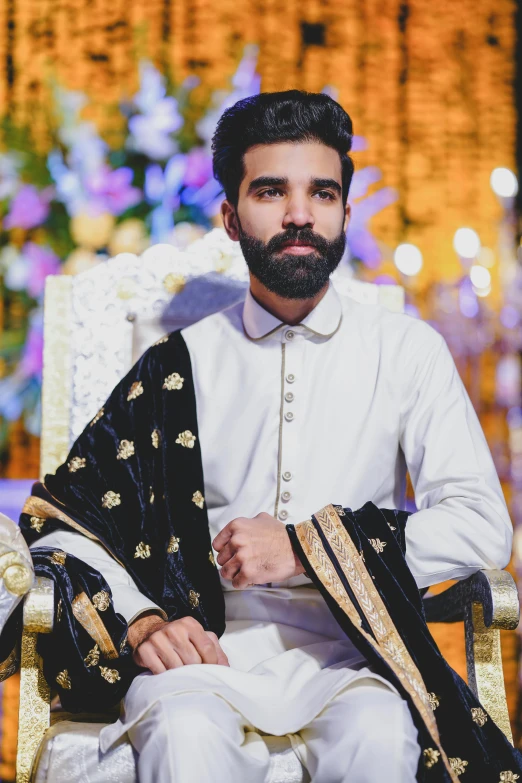 a young man is sitting in a chair with his arms folded