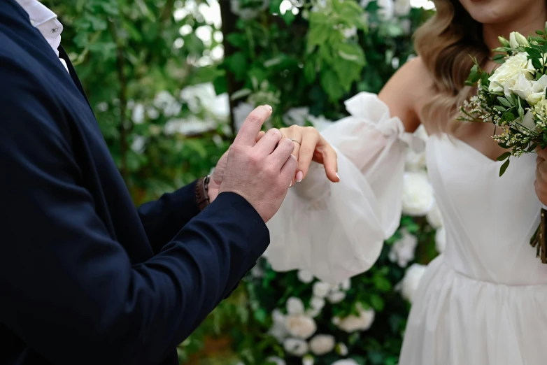 a man is trying to pick his bride's hand