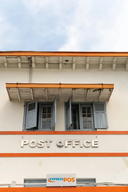 a sign in front of a post office on the side of a building