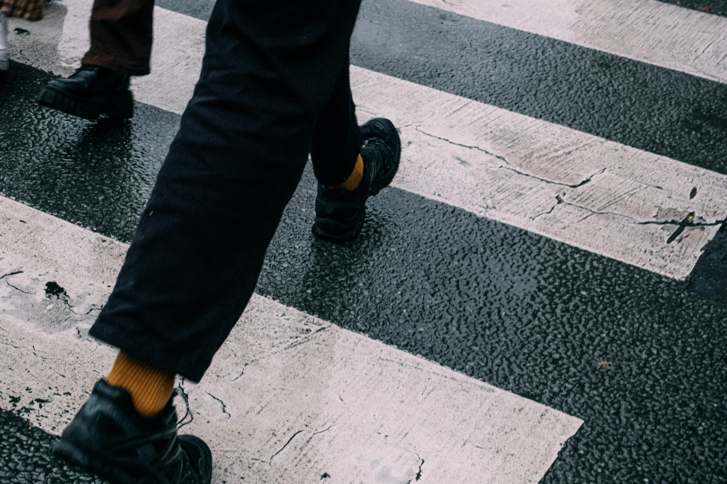 the foot of someone crossing the street on the cross walk