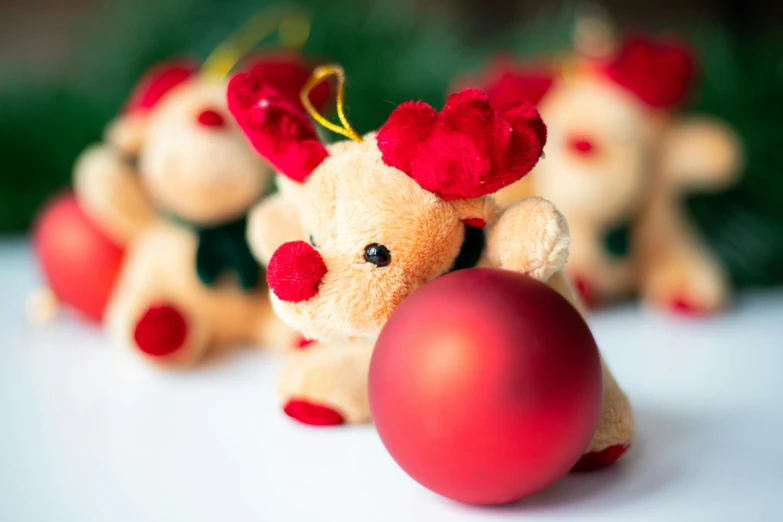 three teddy bears made of red poins and one with a big bow on it