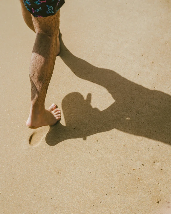 a persons bare leg standing on the sand