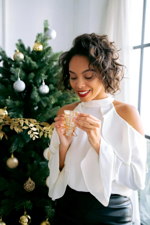 the woman smiles while holding her glass