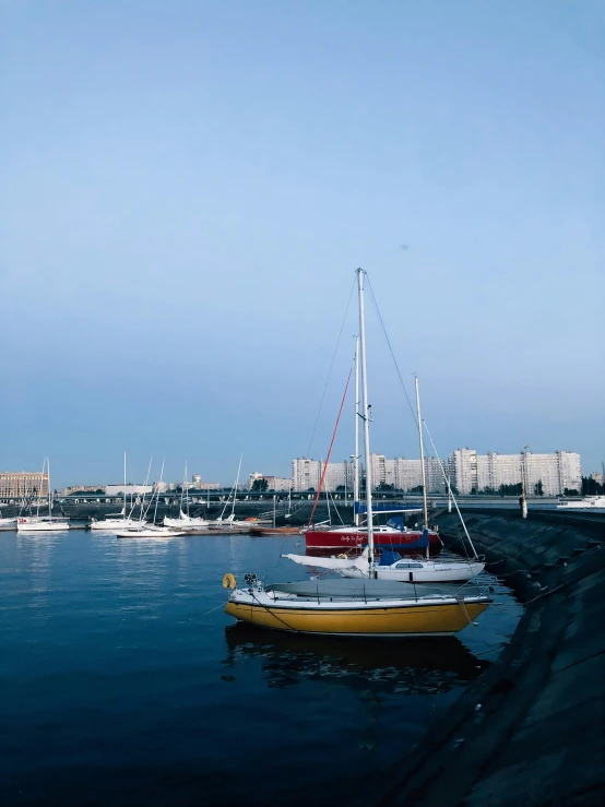 two boats floating on a body of water near some buildings