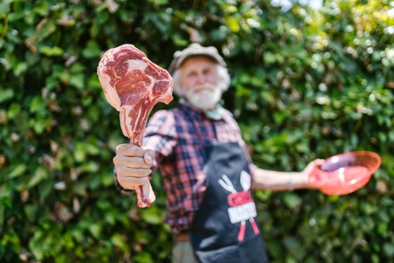 an older man is holding a pair of meat in his hands