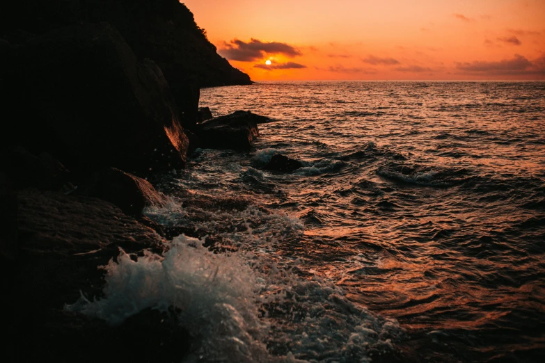 the sun rising over a body of water