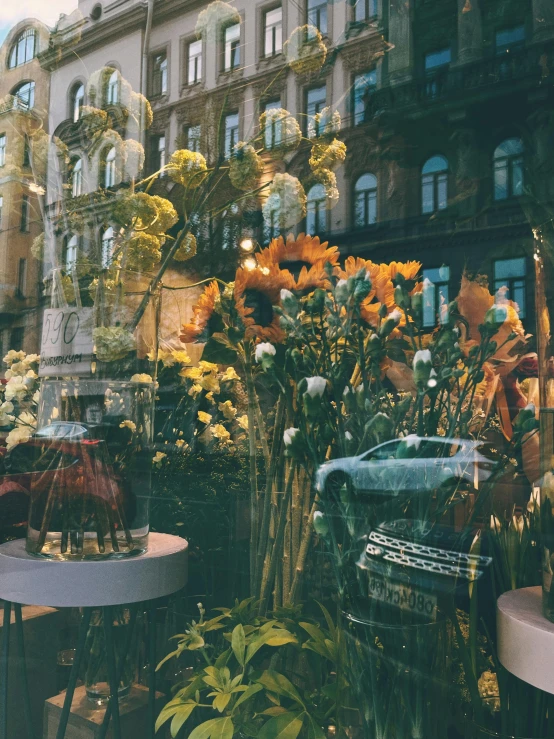 large vases filled with flowers sitting next to each other in front of a building