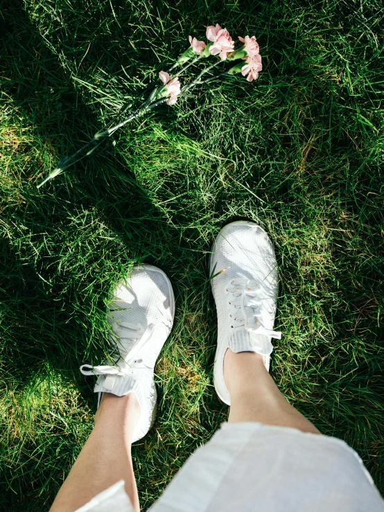 a pair of feet standing on top of green grass