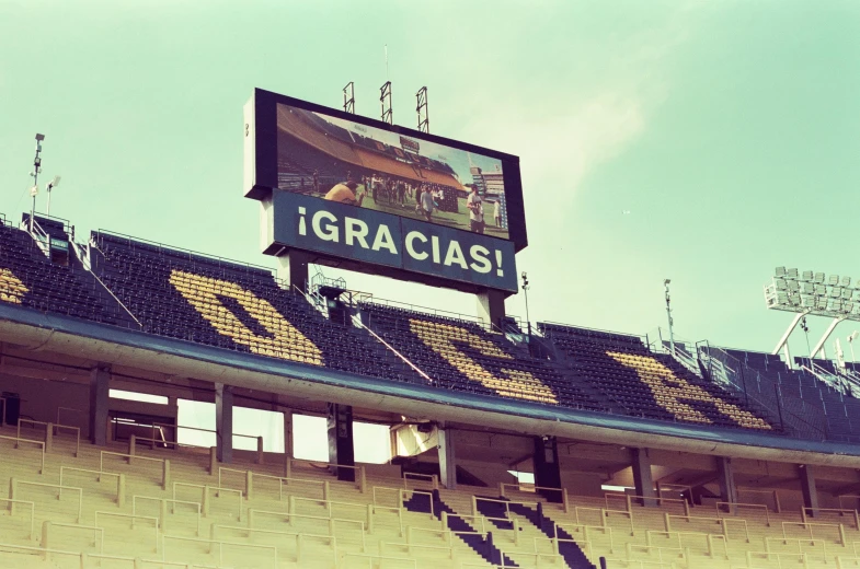 a big screen sign sitting on top of a brown stadium