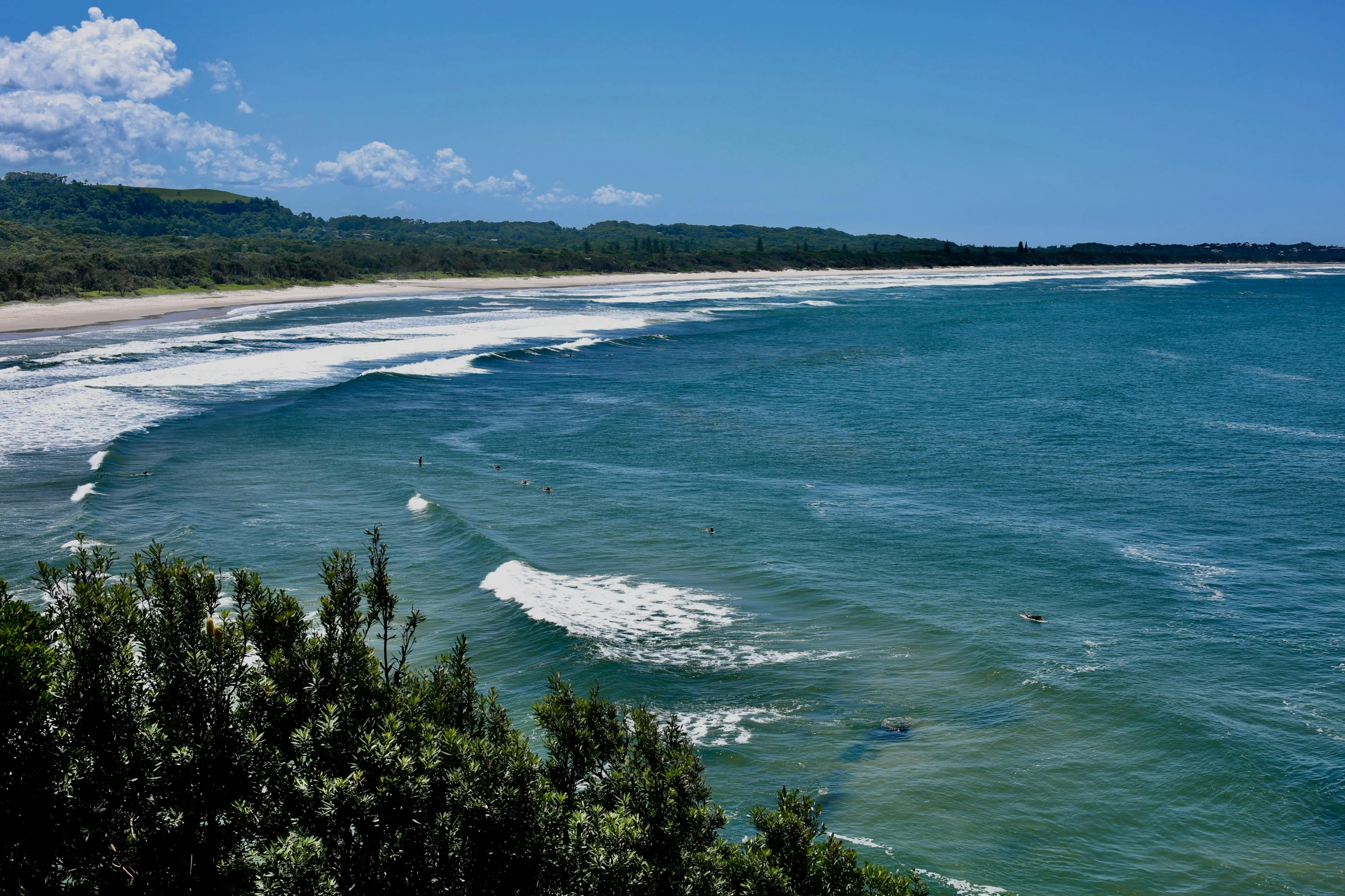 a large body of water with a beach in the background