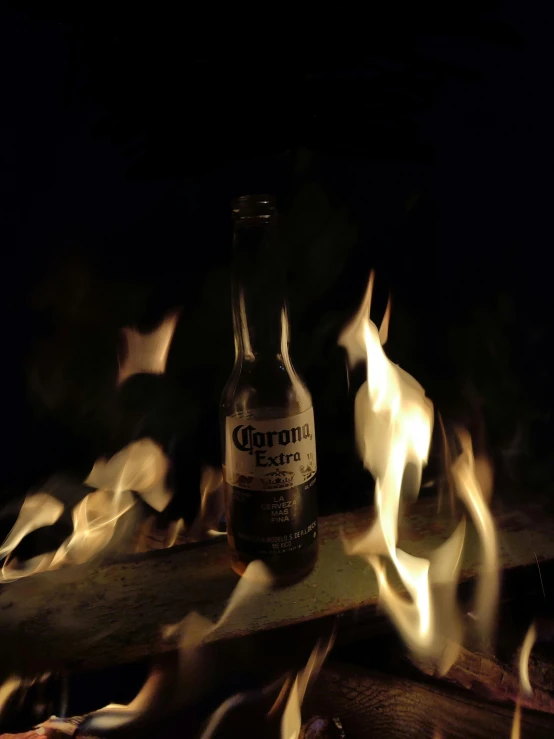 a bottle of beer is on top of a fire