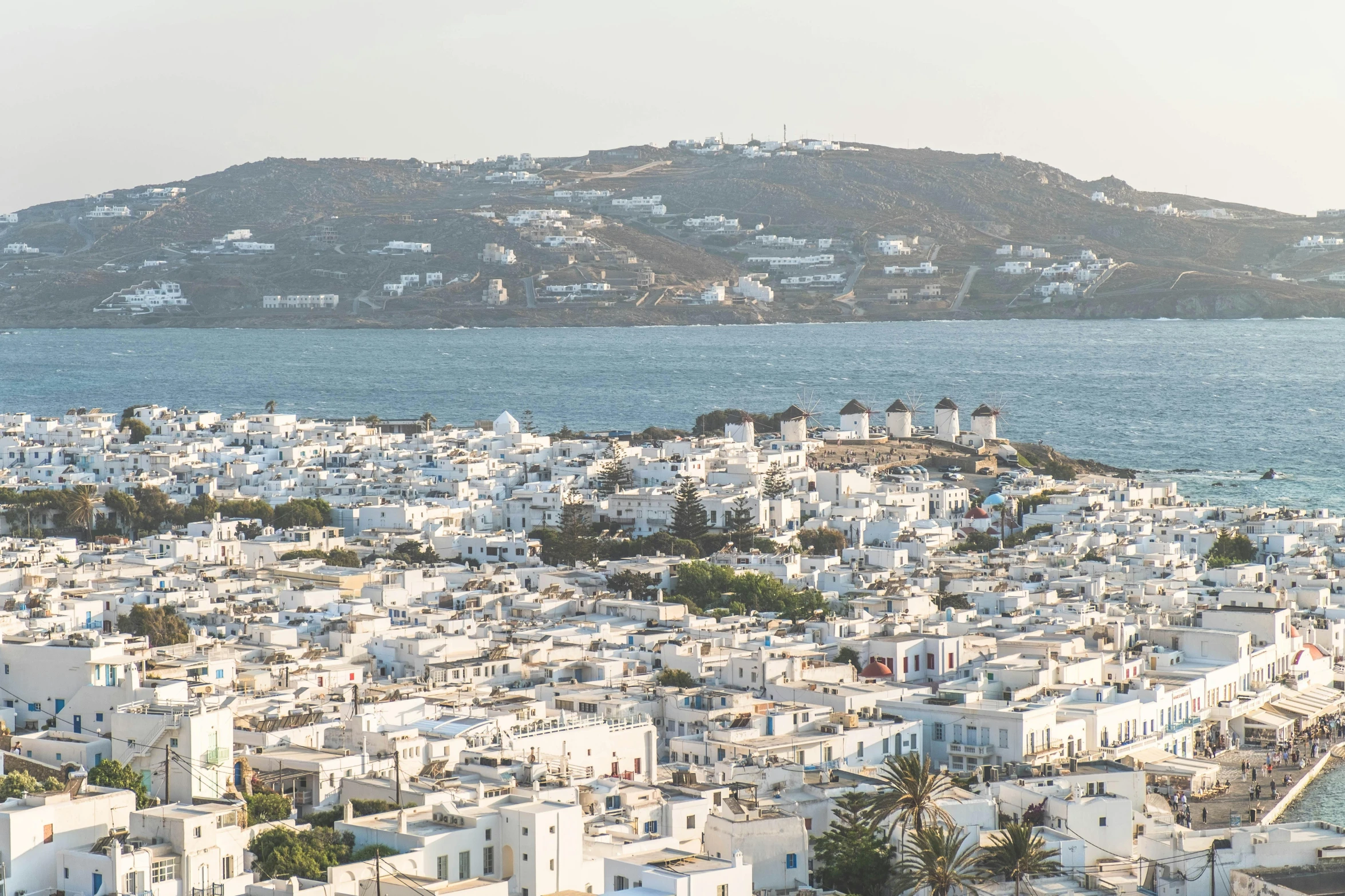 an aerial view of a city with water and hills in the distance