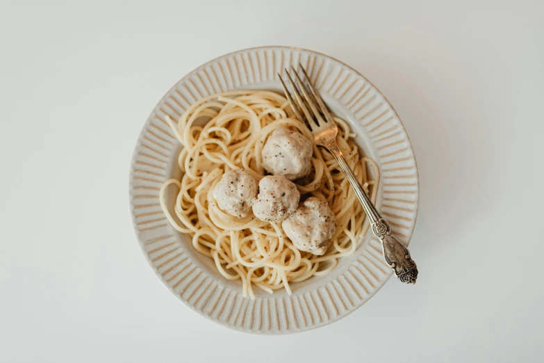 a plate filled with spaghetti with mushrooms and noodles