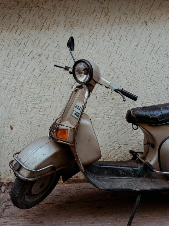 an old scooter with a leather seat parked in front of a building