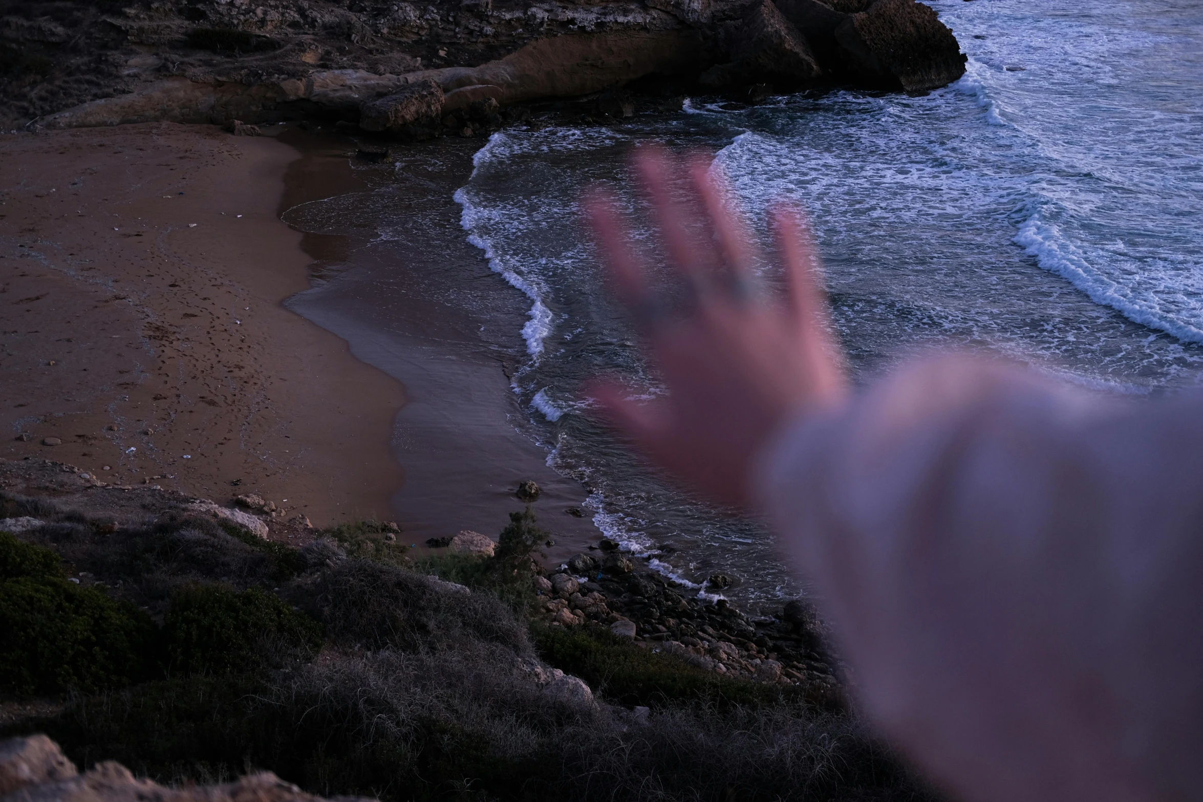 a man reaches to grab a wave from the ocean