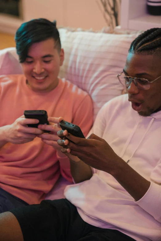 a couple of people sitting down with cell phones