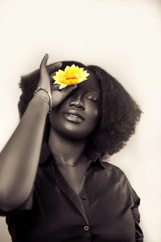 a black woman putting a flower on her eye