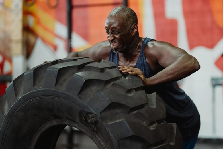 a man holding a tire over the side of a car