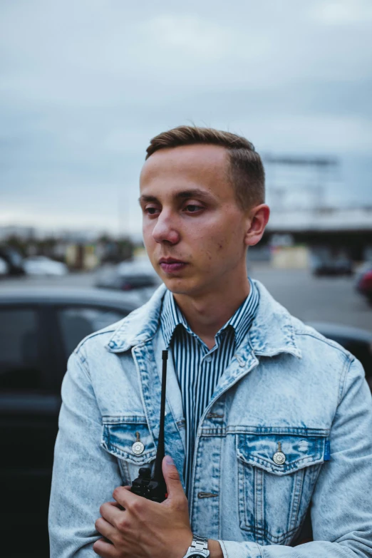 man in a jean jacket standing outdoors