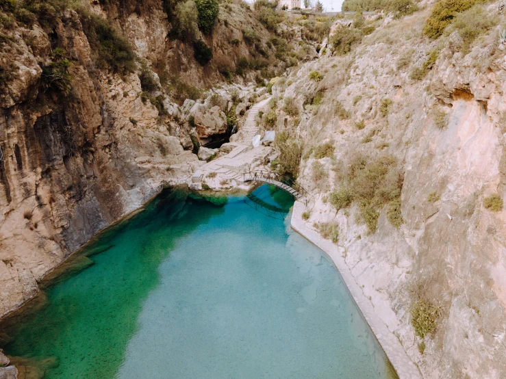 a clear blue lake is situated in a rocky gorge